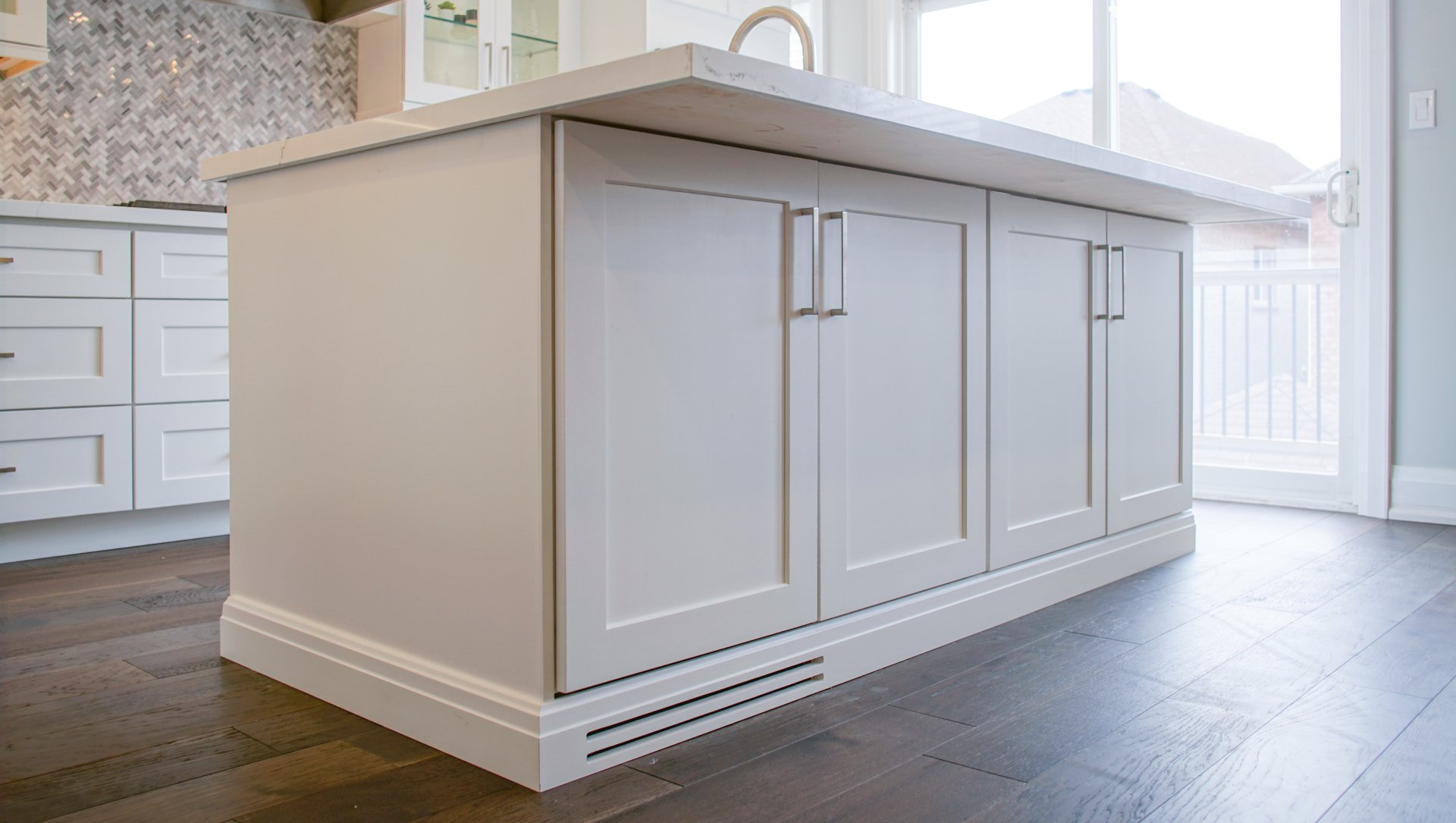 a renovated kitchen island with white cabinets and a white counter top .