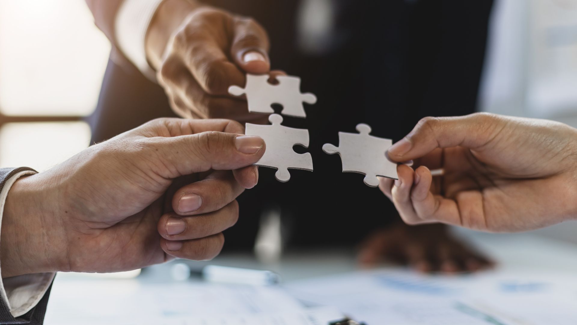 A group of people are putting puzzle pieces together.