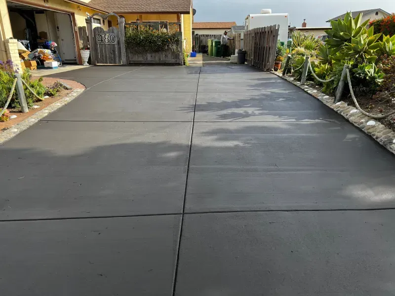 Newly poured gray concrete driveway.