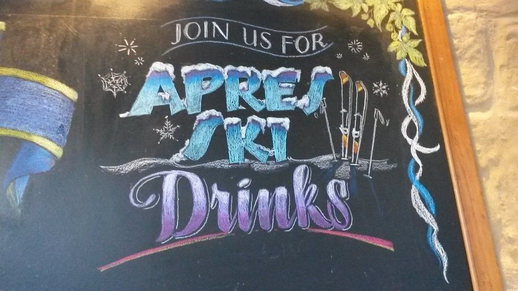 A chalkboard that says join us for apres ski drinks