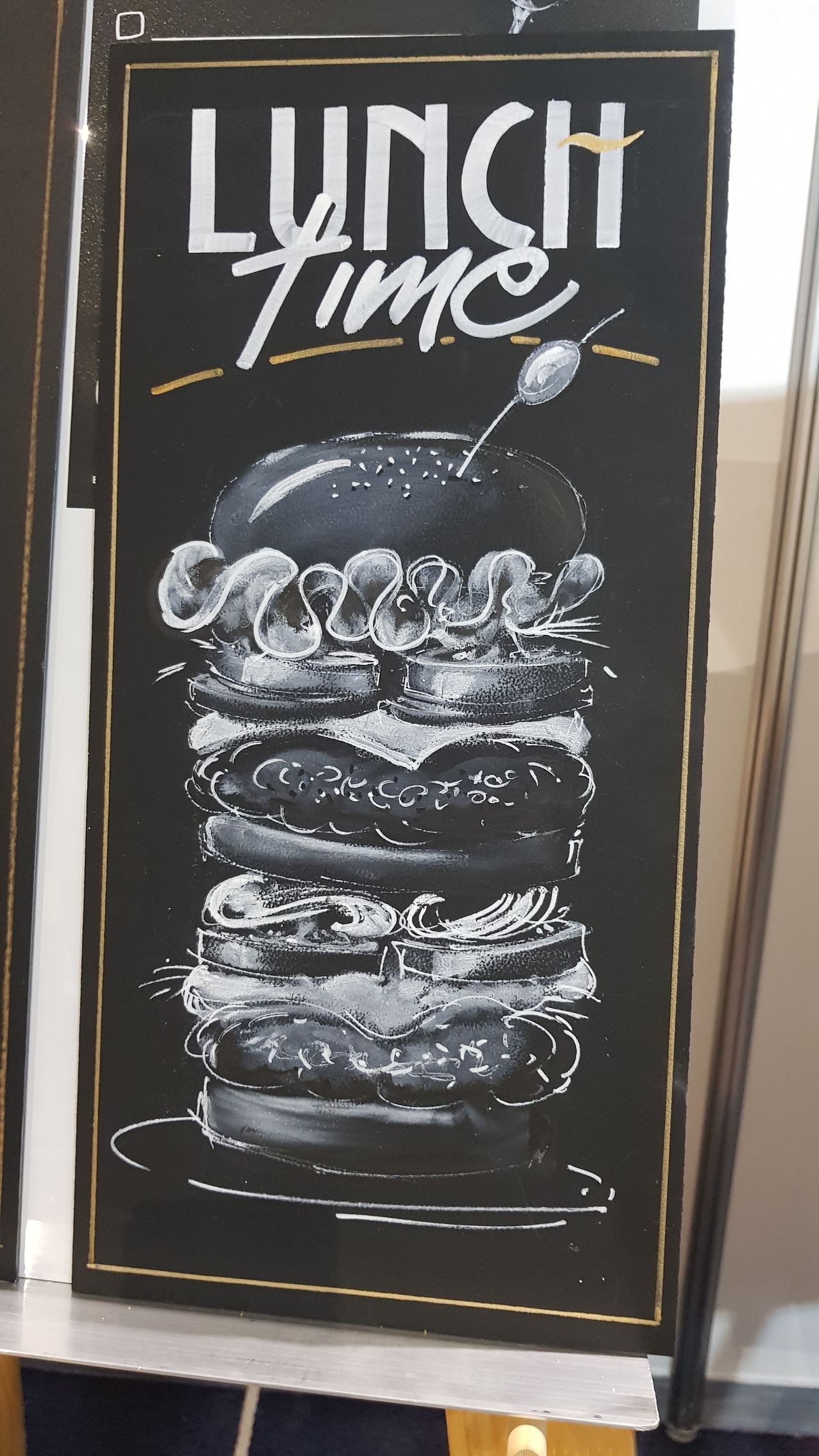 A woman is standing in front of a wall with drawings of cities on it.