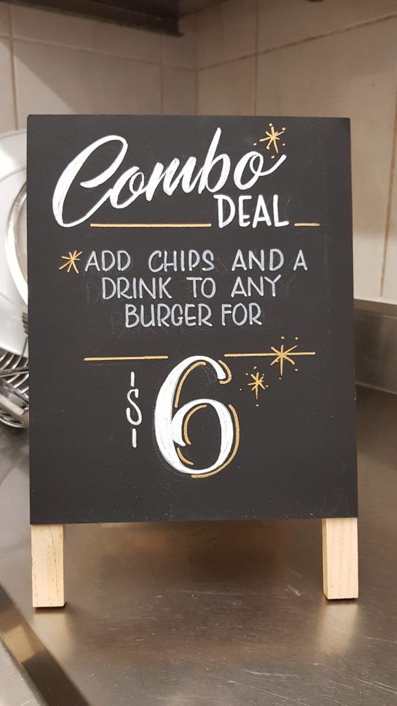 A sign that says combo deal add chips and a drink to any burger for $ 6