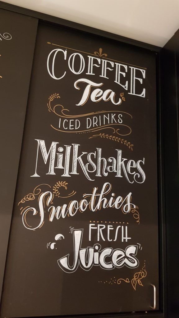 A chalkboard that says coffee tea iced drinks milkshakes smoothies fresh juices