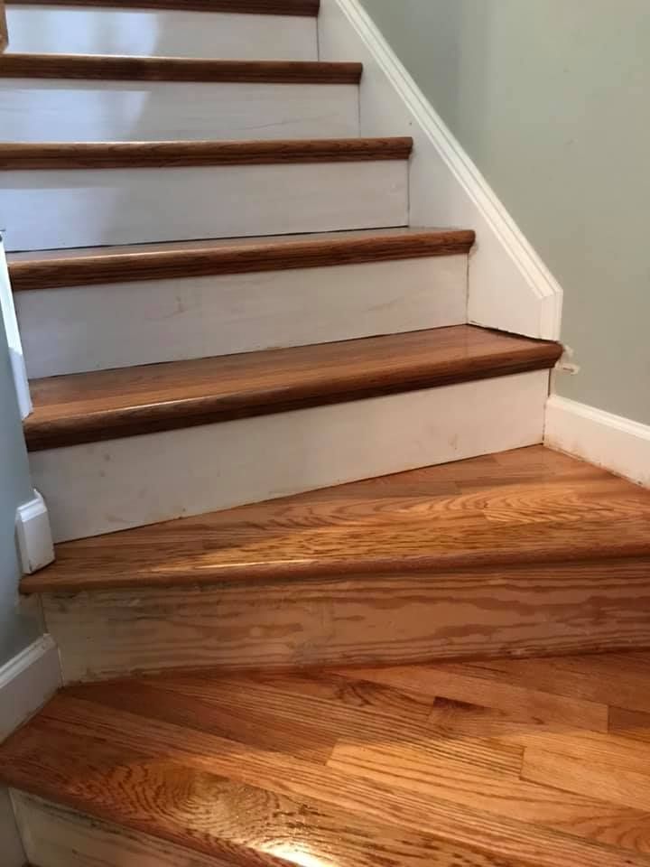 Wooden staircase with white risers, brown treads, and a white banister.