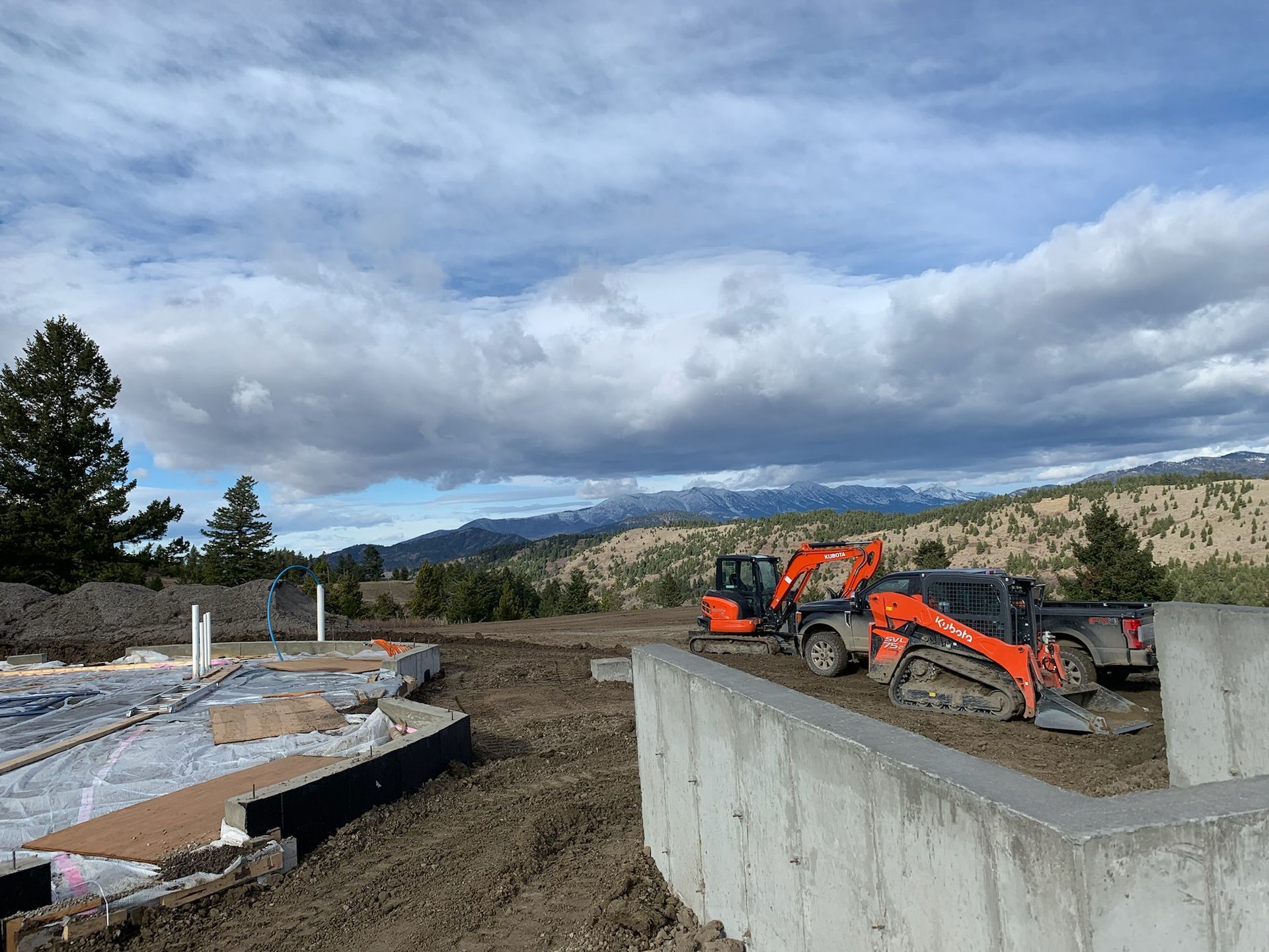 A bulldozer is parked next to a concrete wall on a construction site.