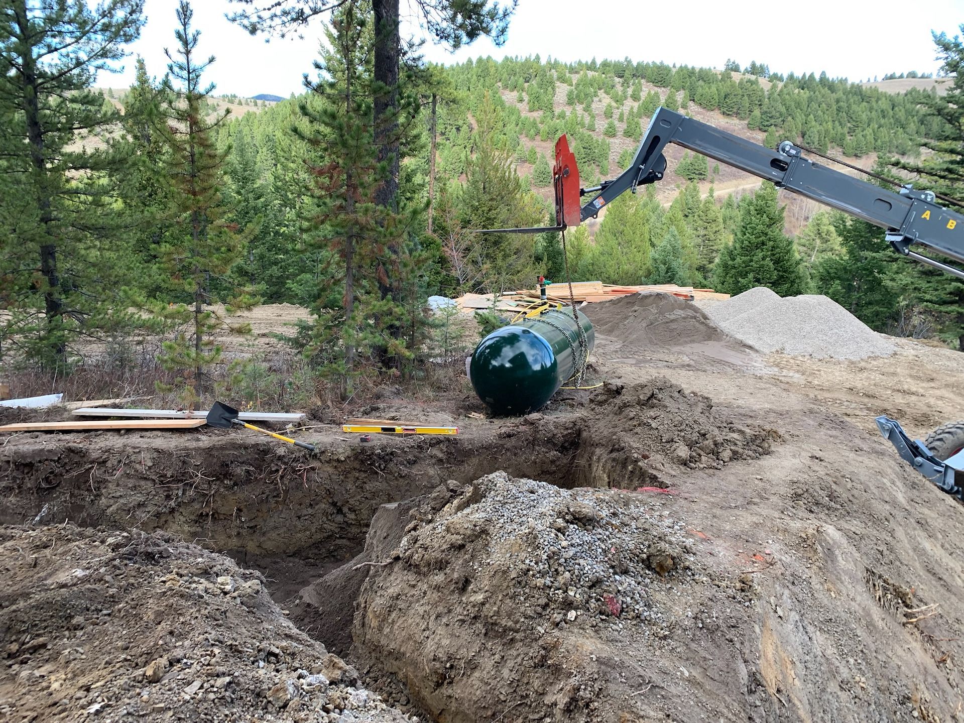 A crane is lifting a large object out of a hole in the ground.