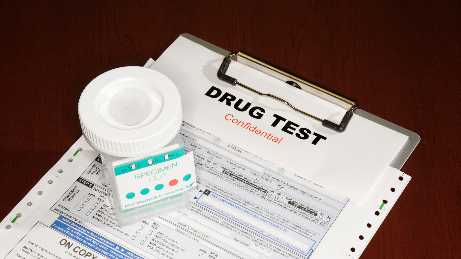 A bottle of pills is sitting on top of a drug test form.