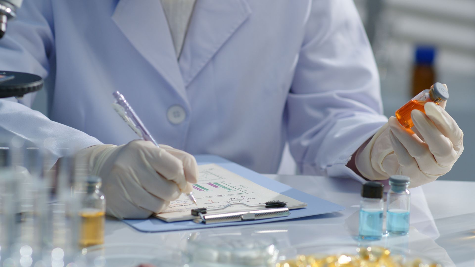 A syringe is sitting on top of a pile of pills and capsules.