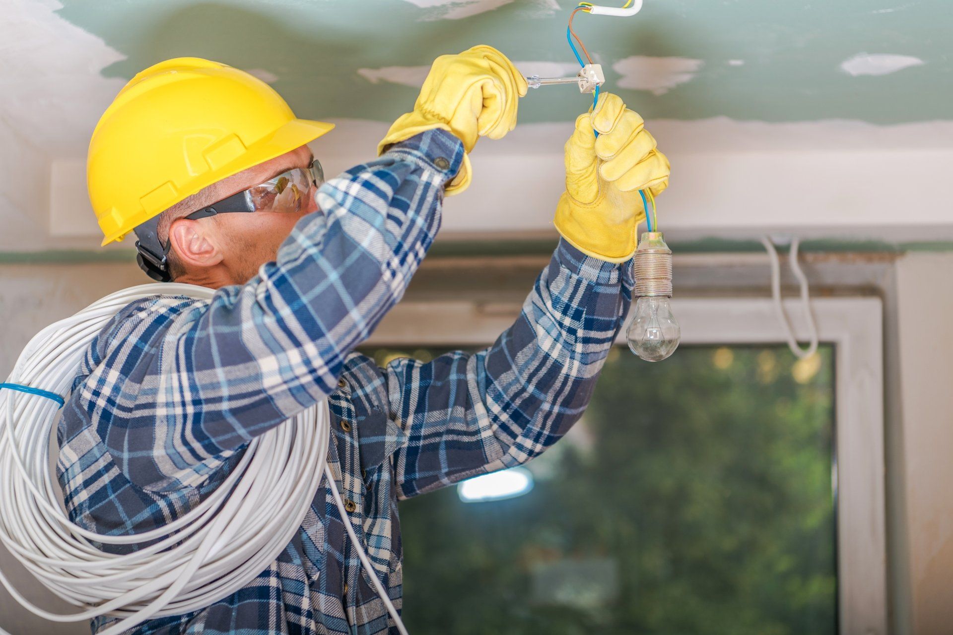 electrician fixing a ceiling light bulb wire