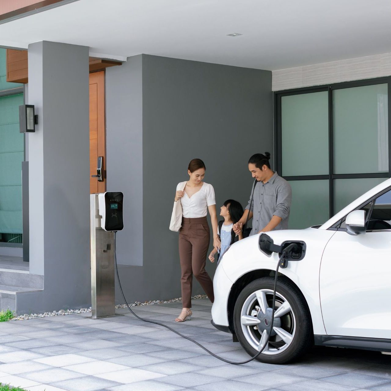 a family is charging their electric car at a charging station