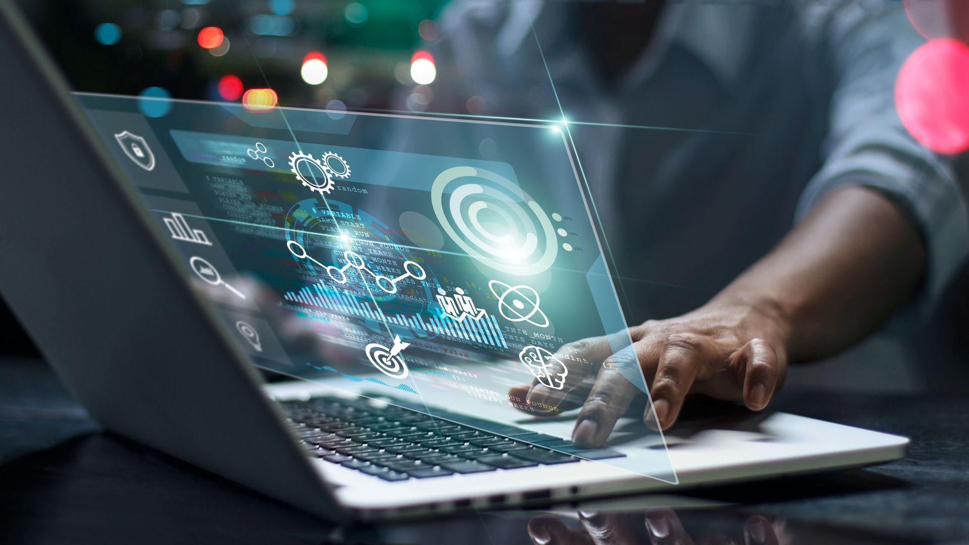 Person using laptop with holographic data display.