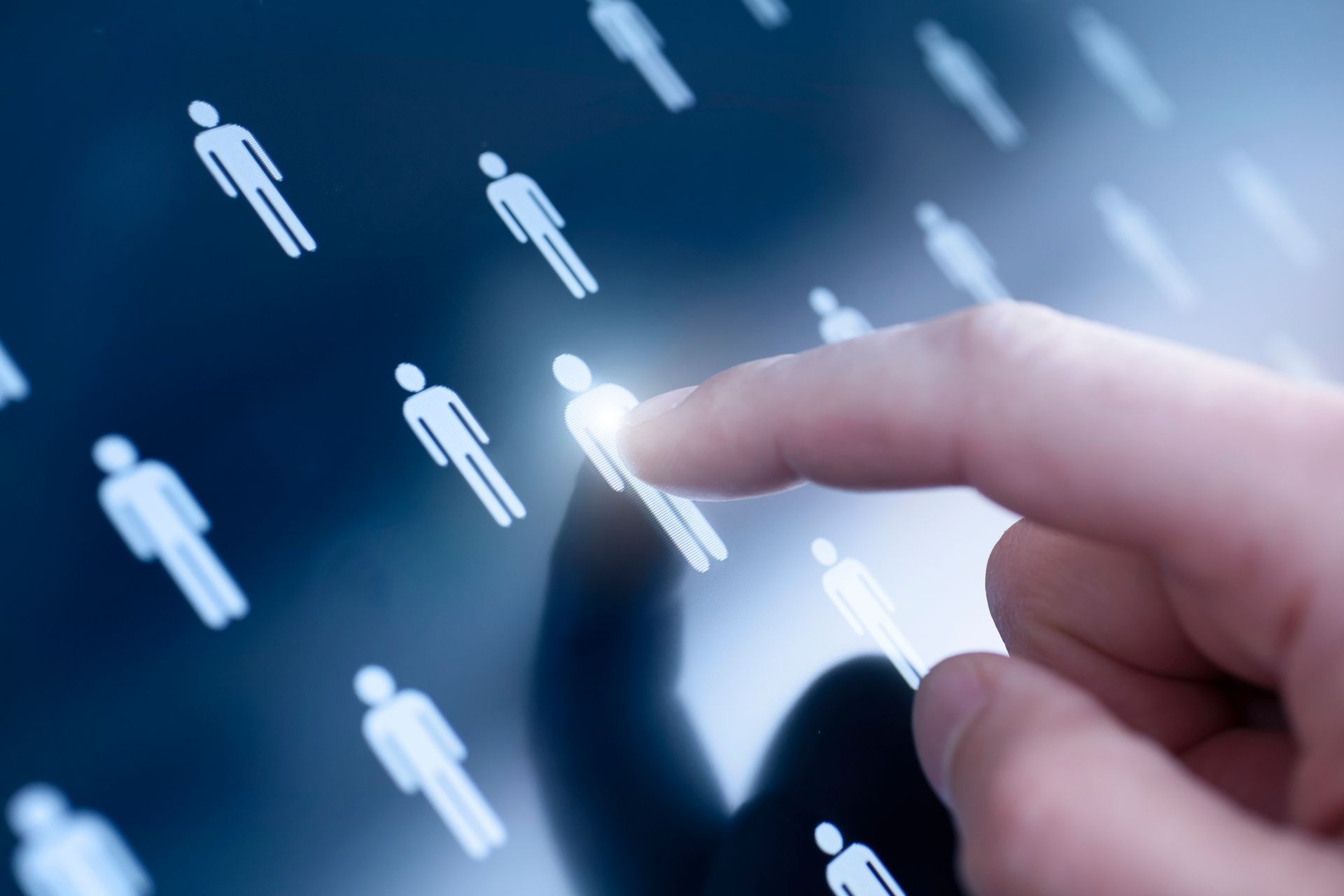 Hand selecting a highlighted figure icon on a digital screen, surrounded by other icons.