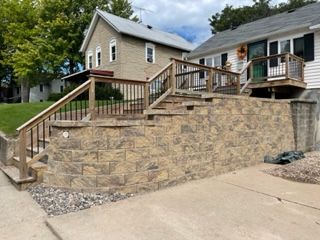 A brick wall with stairs leading up to a house