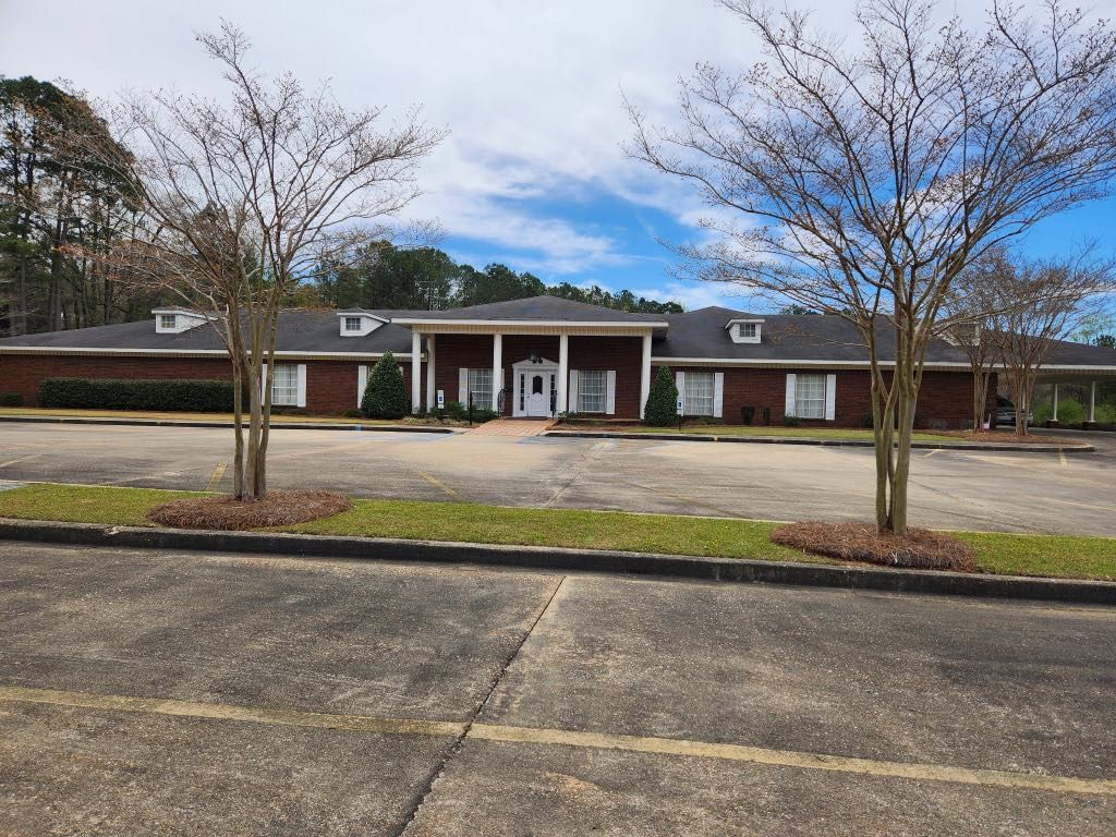 A large brick building with a parking lot in front of it.