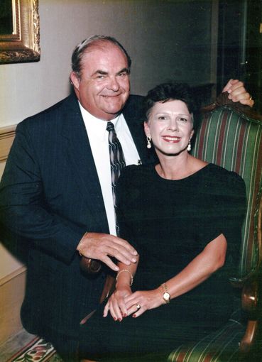A woman wearing a black and white plaid jacket smiles for the camera