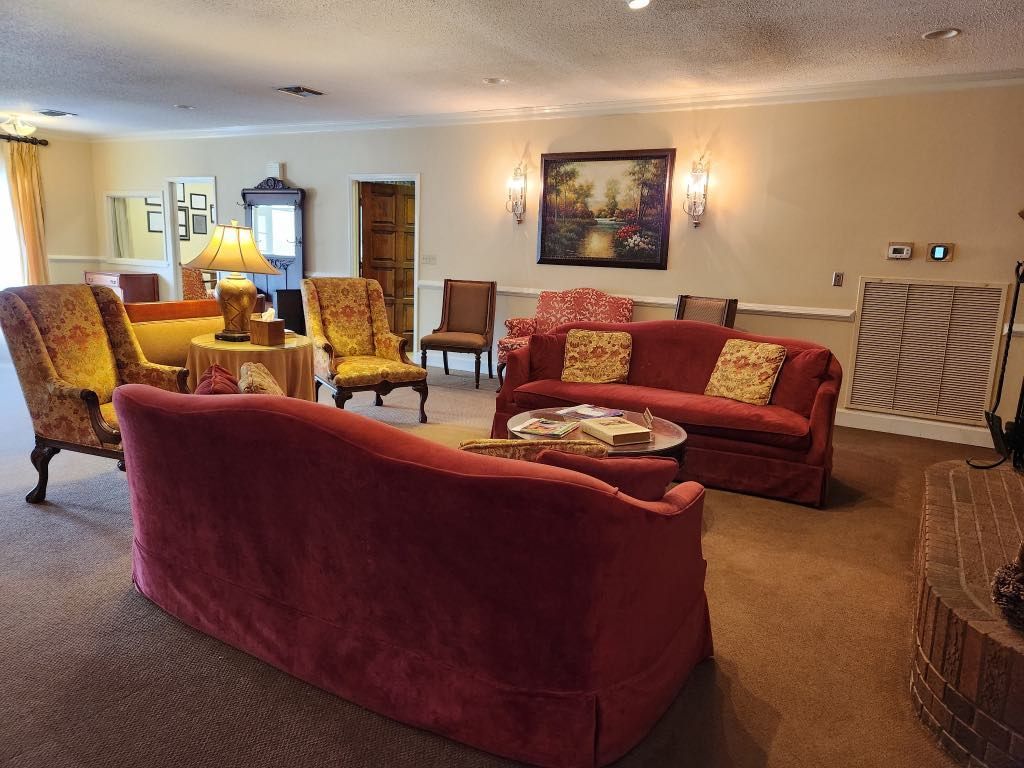 A living room with a red couch and chairs