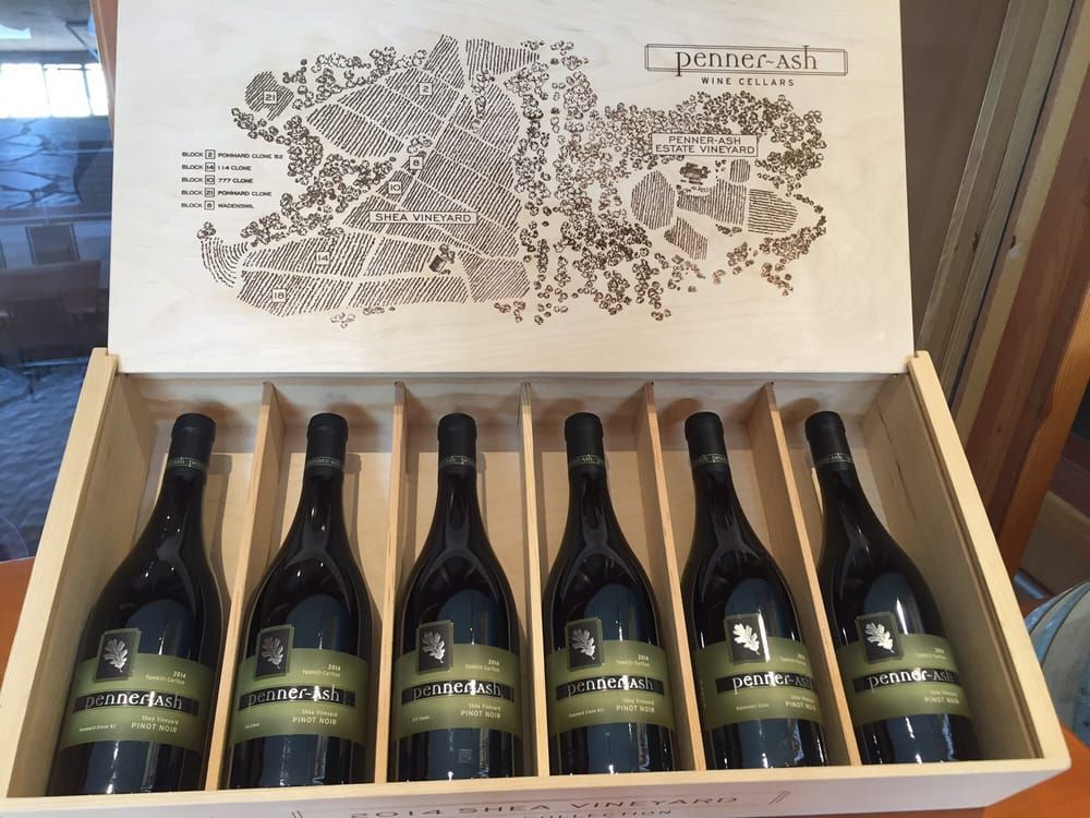 Six bottles of red wine in a wooden box, showcasing the winery's map on the lid.
