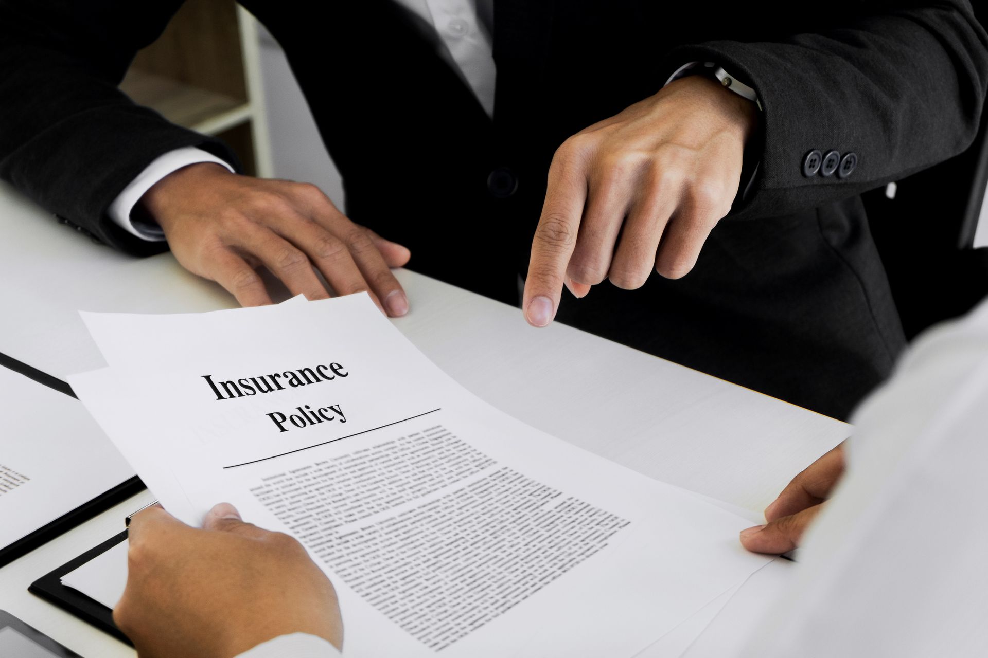 An insurance agent, from an insurance agency, explains policy form to a customer.