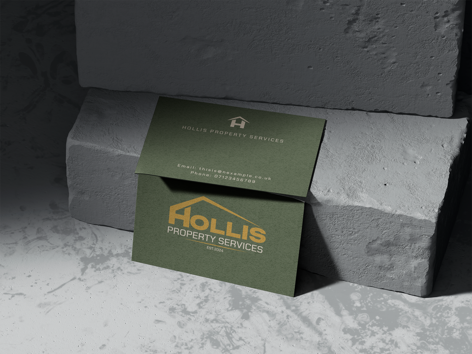 Two business cards are sitting on top of each other on a concrete surface.