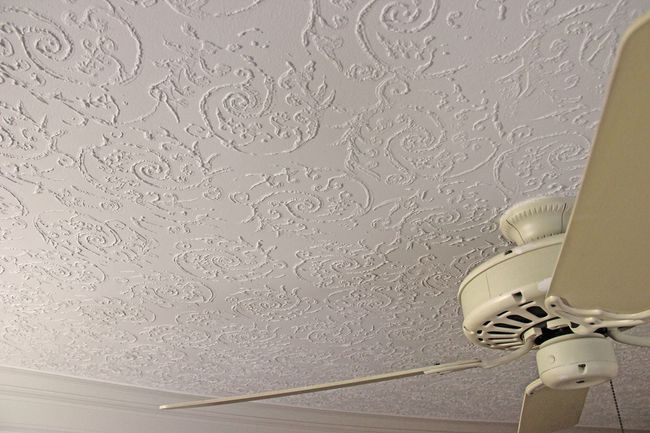 a white ceiling fan is hanging from the ceiling of a room .