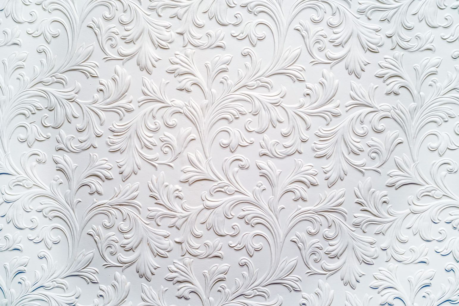 a close up of a white wall with a floral pattern on it .
