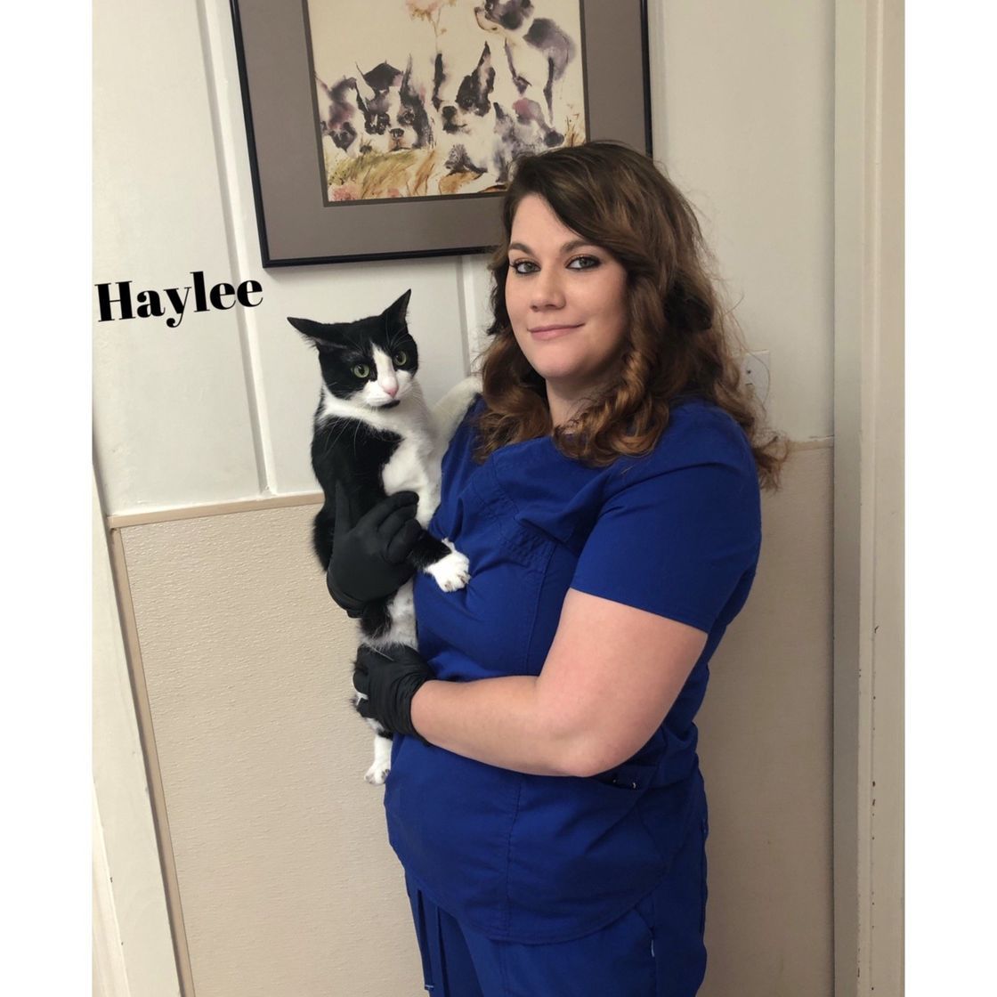 Haylee is holding a black and white cat in her arms.