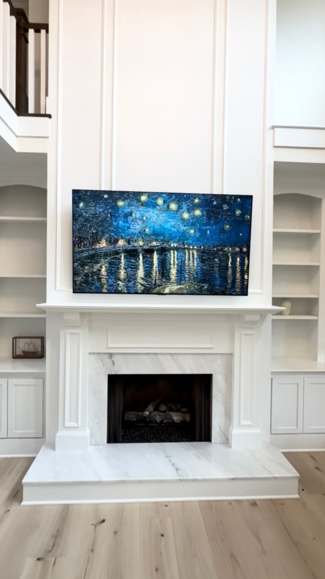A living room with a fireplace and a painting on the wall above it.