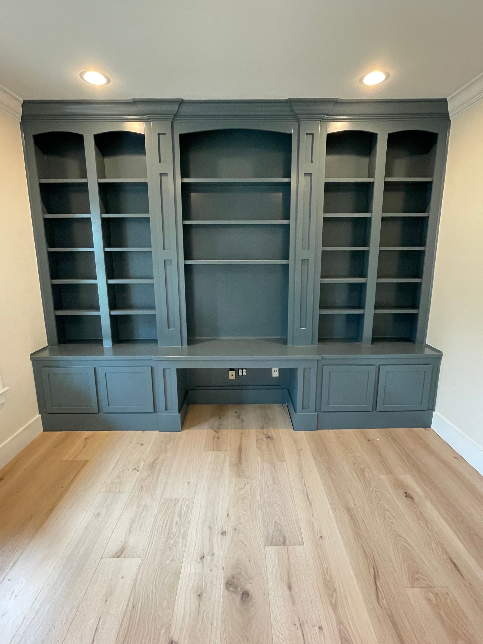 An empty room with a bookshelf and a desk