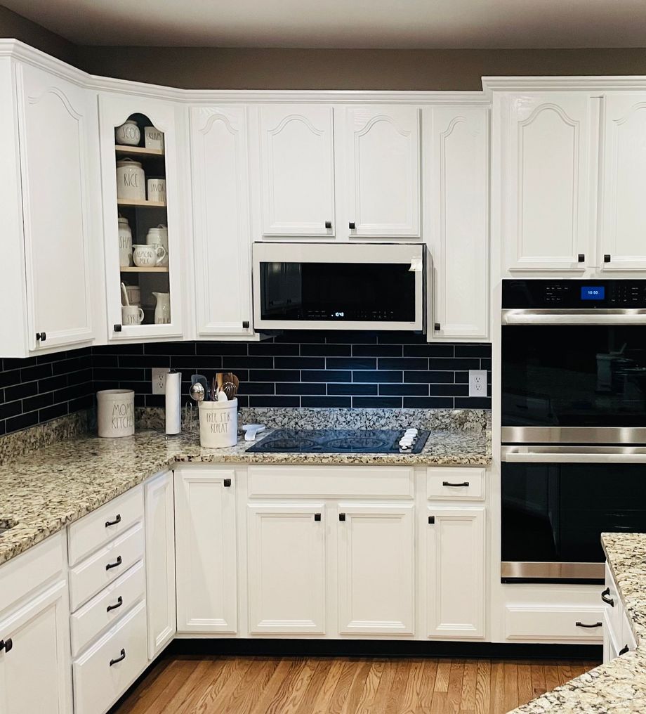 A kitchen with white cabinets and granite counter tops