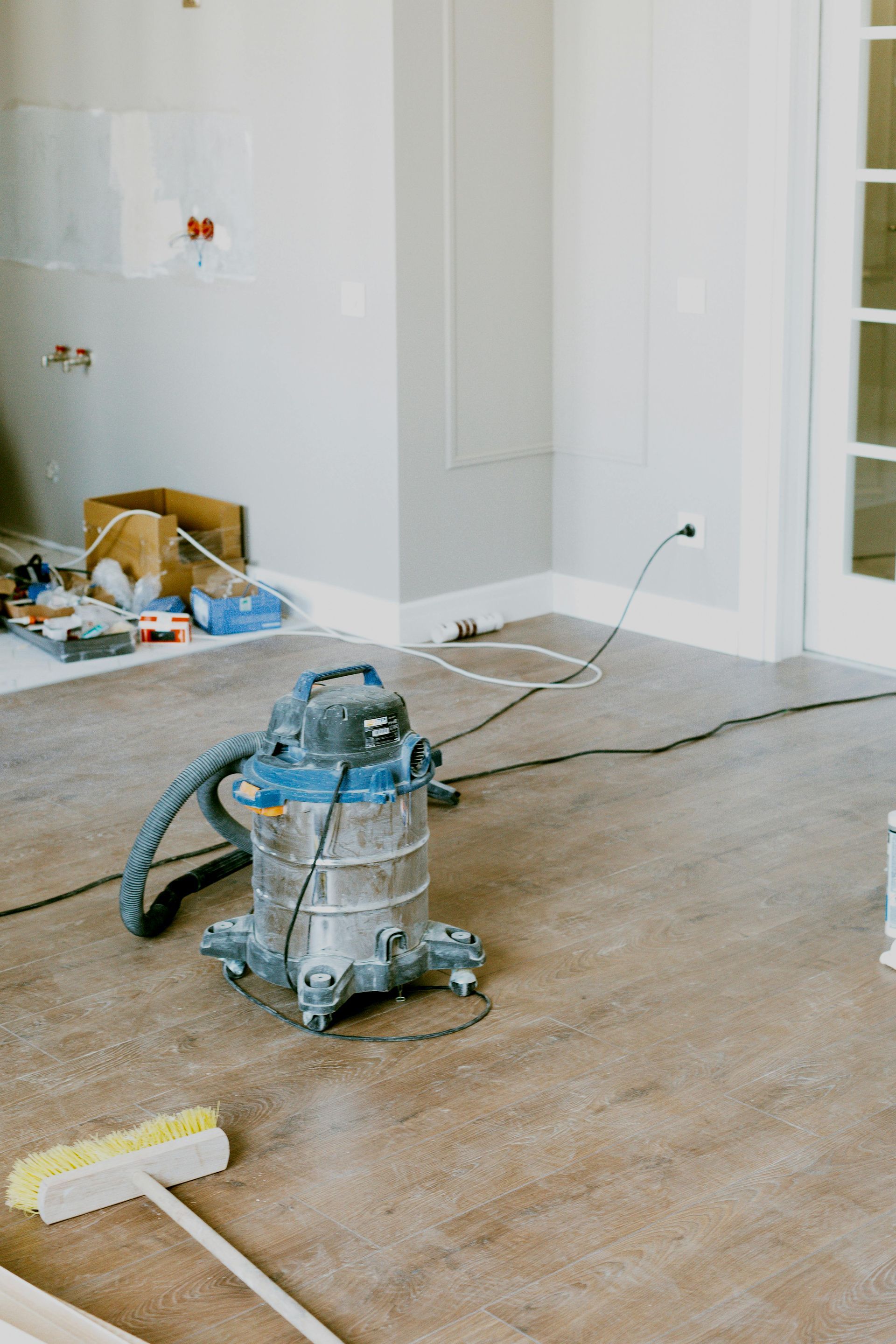 A vacuum cleaner is sitting on the floor in a room under construction.