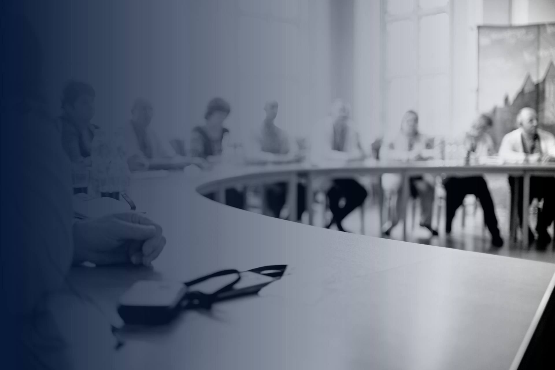 A group of people are sitting around a table in a conference room.