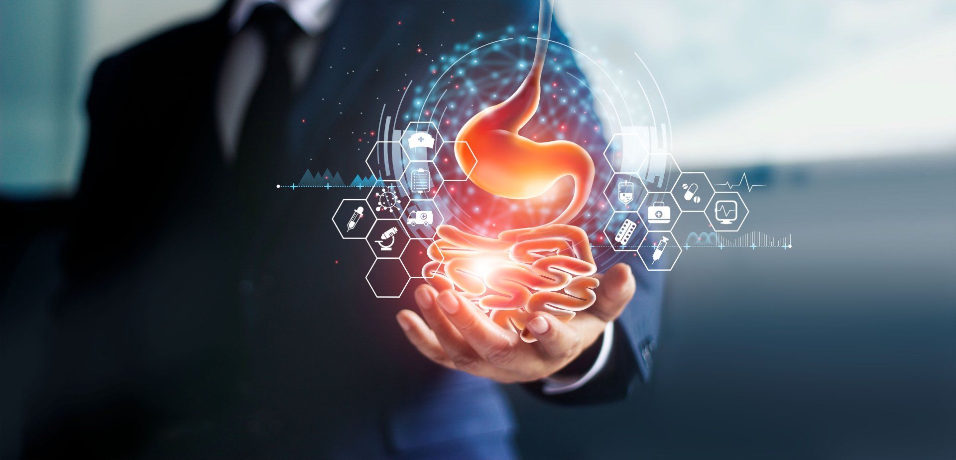 Hand holding a graphic image of the gastrointestinal tract.