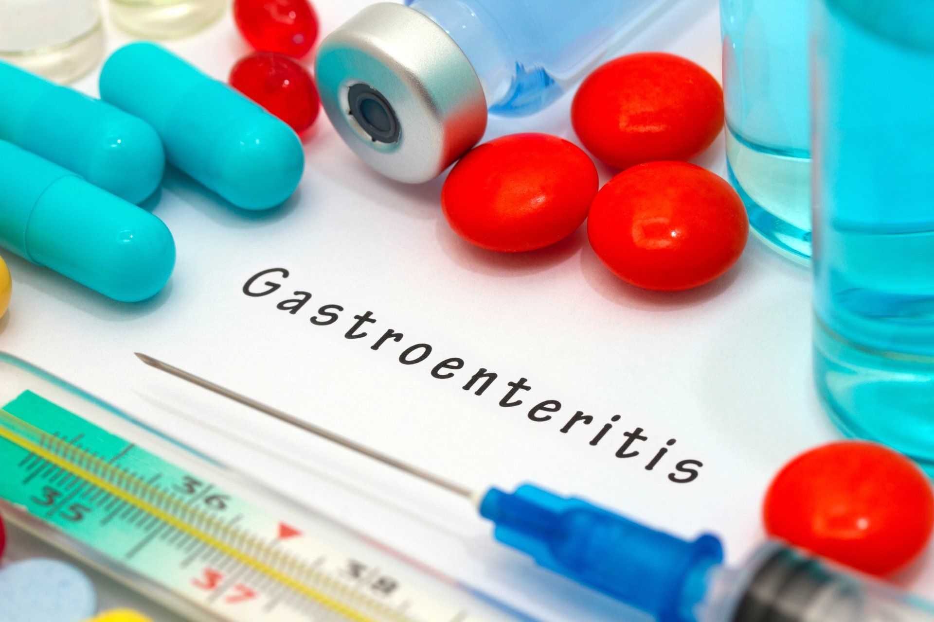 A sign that reads Gastroenteritis with medicine and a needle laying on it.