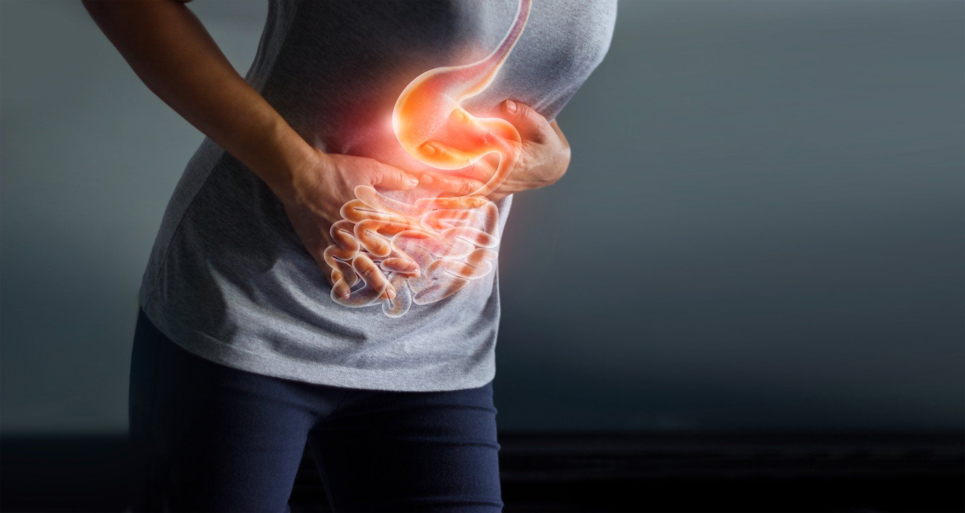 A person holding their stomach with a superimposed image of the gastrointestinal tract.