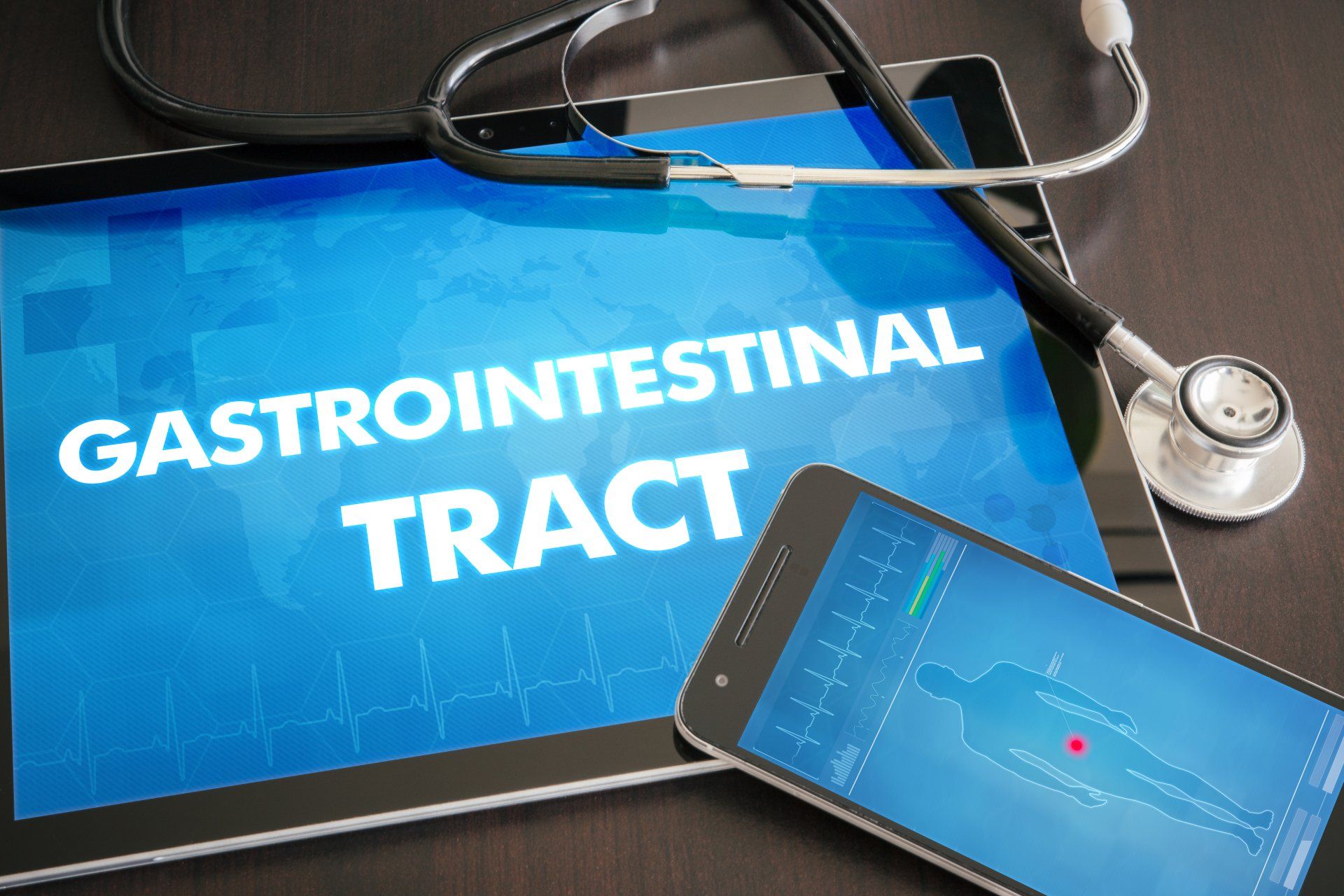 Tablet that says Gatrointestinal Tract on table with a phone and stethoscope.