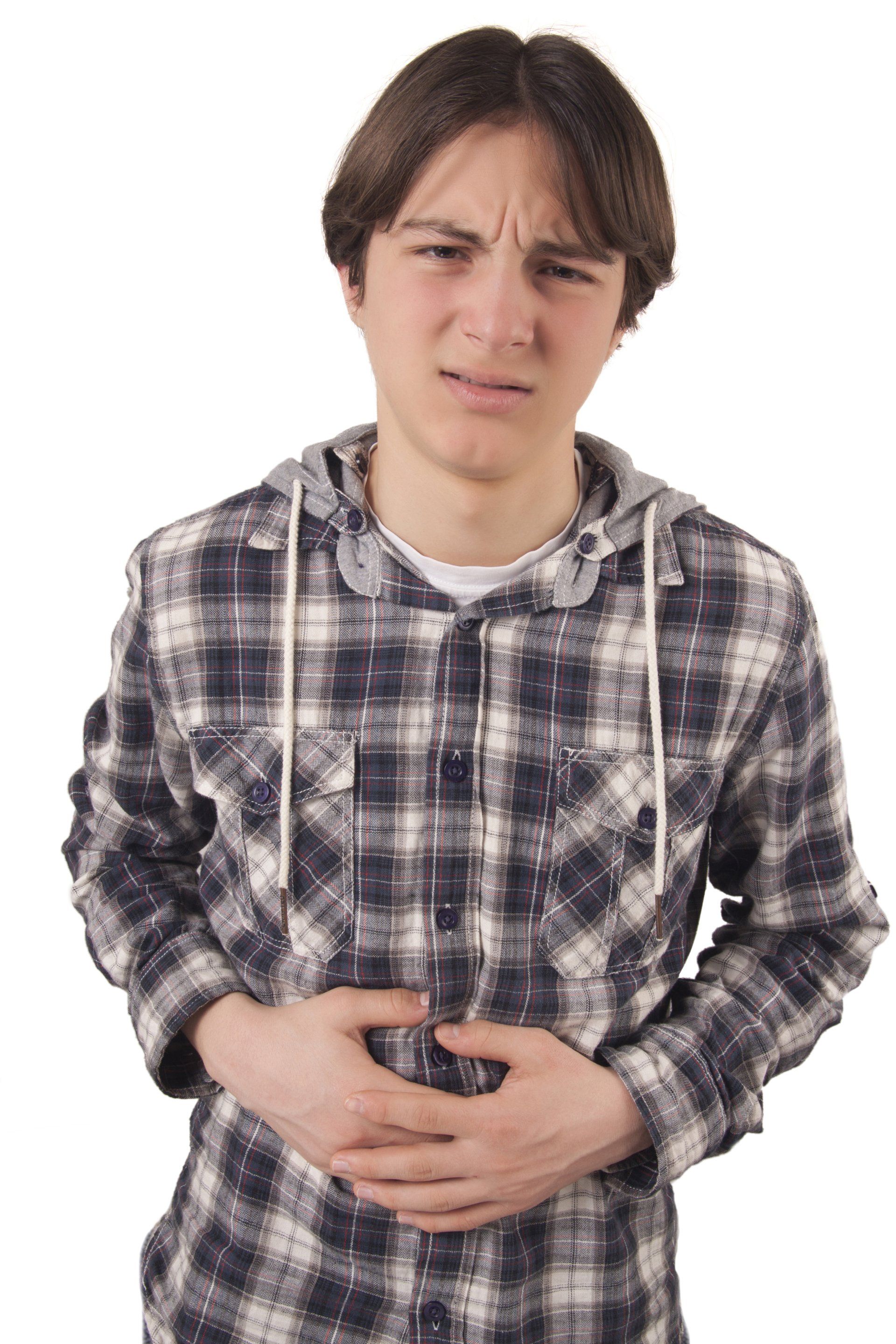 Young man holding his stomach with a look of discomfort on his face.