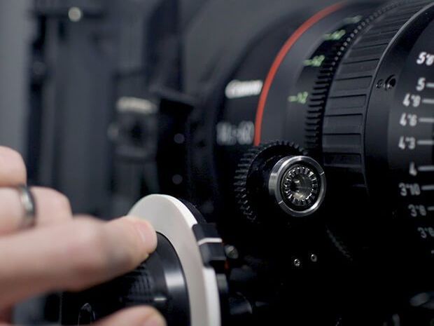 a canon camera with two lenses and a flash on a white background .