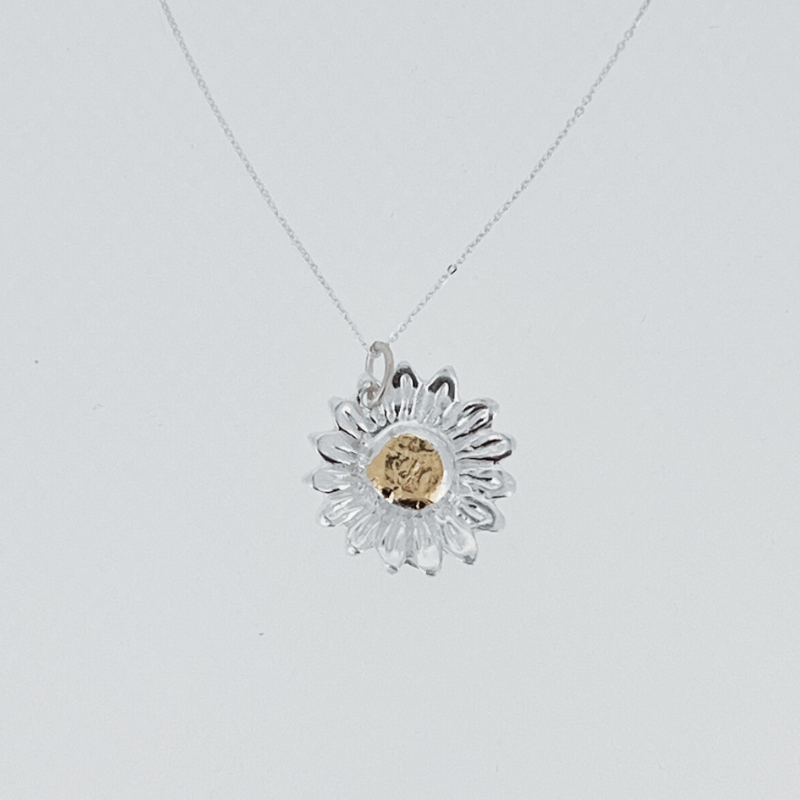 A necklace with a pendant in the shape of a sunflower on a chain.