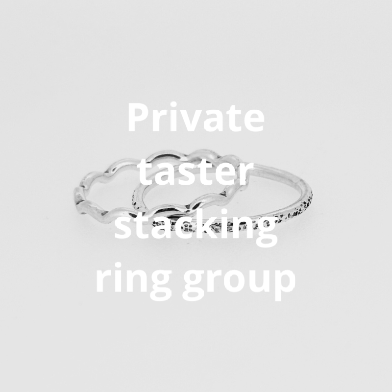 Two silver rings are stacked on top of each other on a white surface.