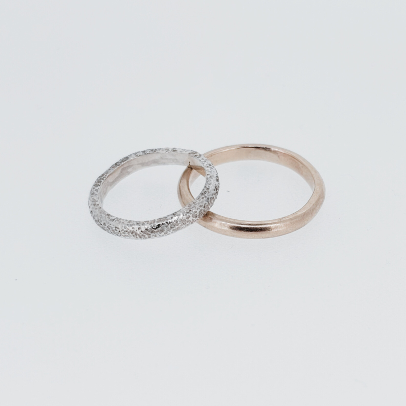 Two rings are sitting next to each other on a white surface