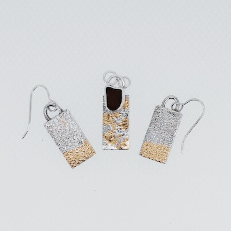 A pair of earrings and a pendant on a white surface