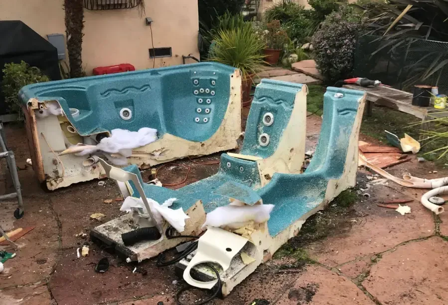 A man in a red shirt is standing in front of a pile of trash