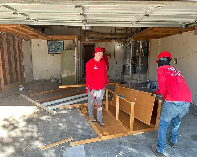A man in a red shirt is doing light demolition