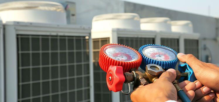 A person is holding a pair of gauges in front of a building.