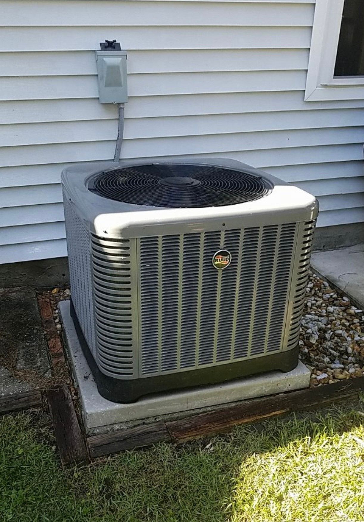 An air conditioner is sitting on the side of a house.