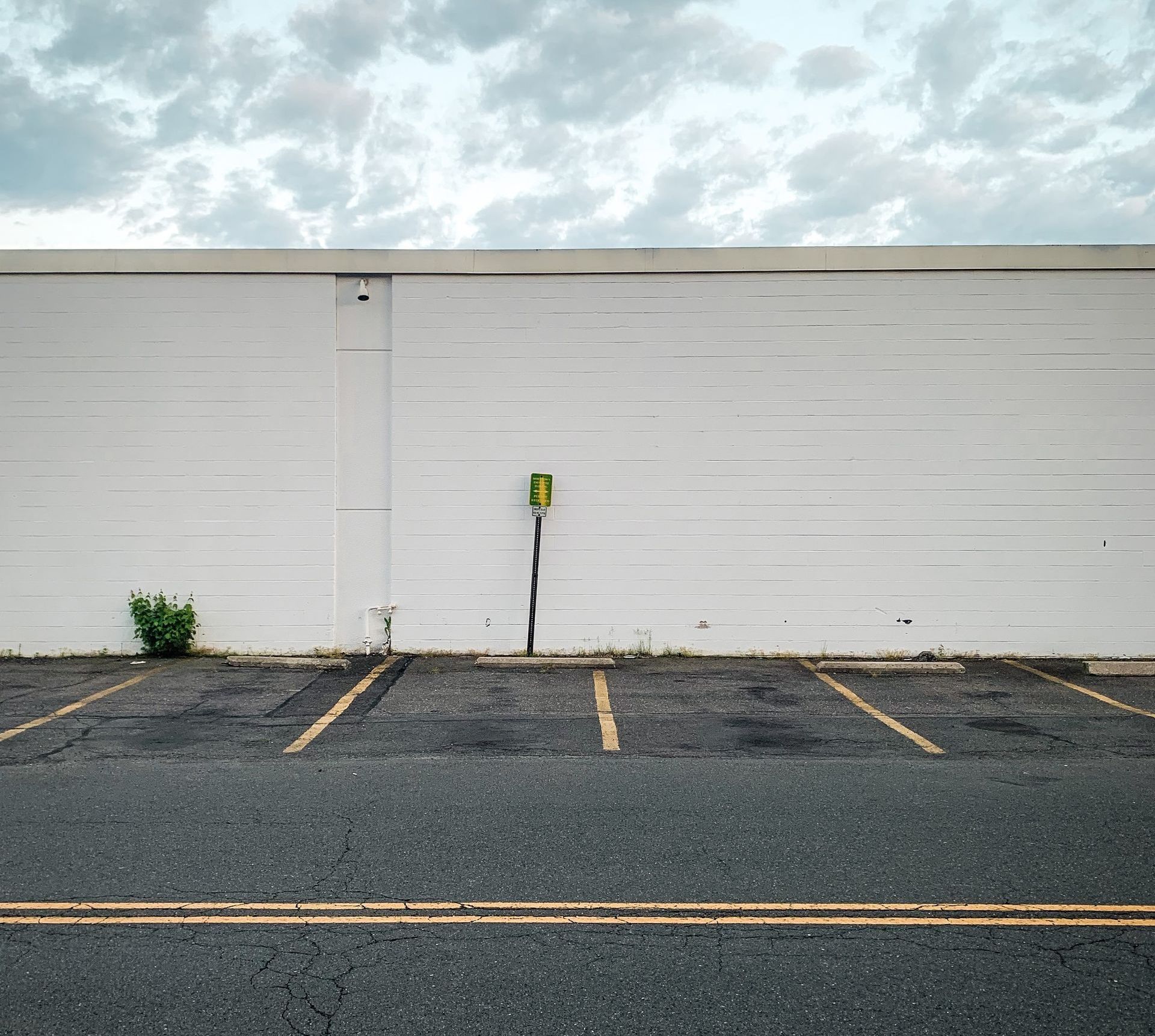 An empty parking lot with yellow lines, waiting for vehicles to fill the spaces.