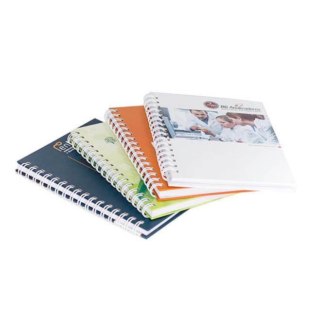 Cuatro cuadernos de espiral de distintos colores, apilados. 
