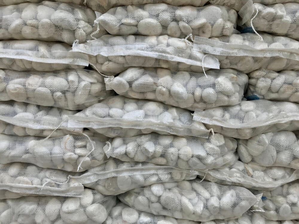 Stacks of Mesh Bags Filled With Pebbles — Ourimbah Landscape Supplies In Ourimbah, NSW