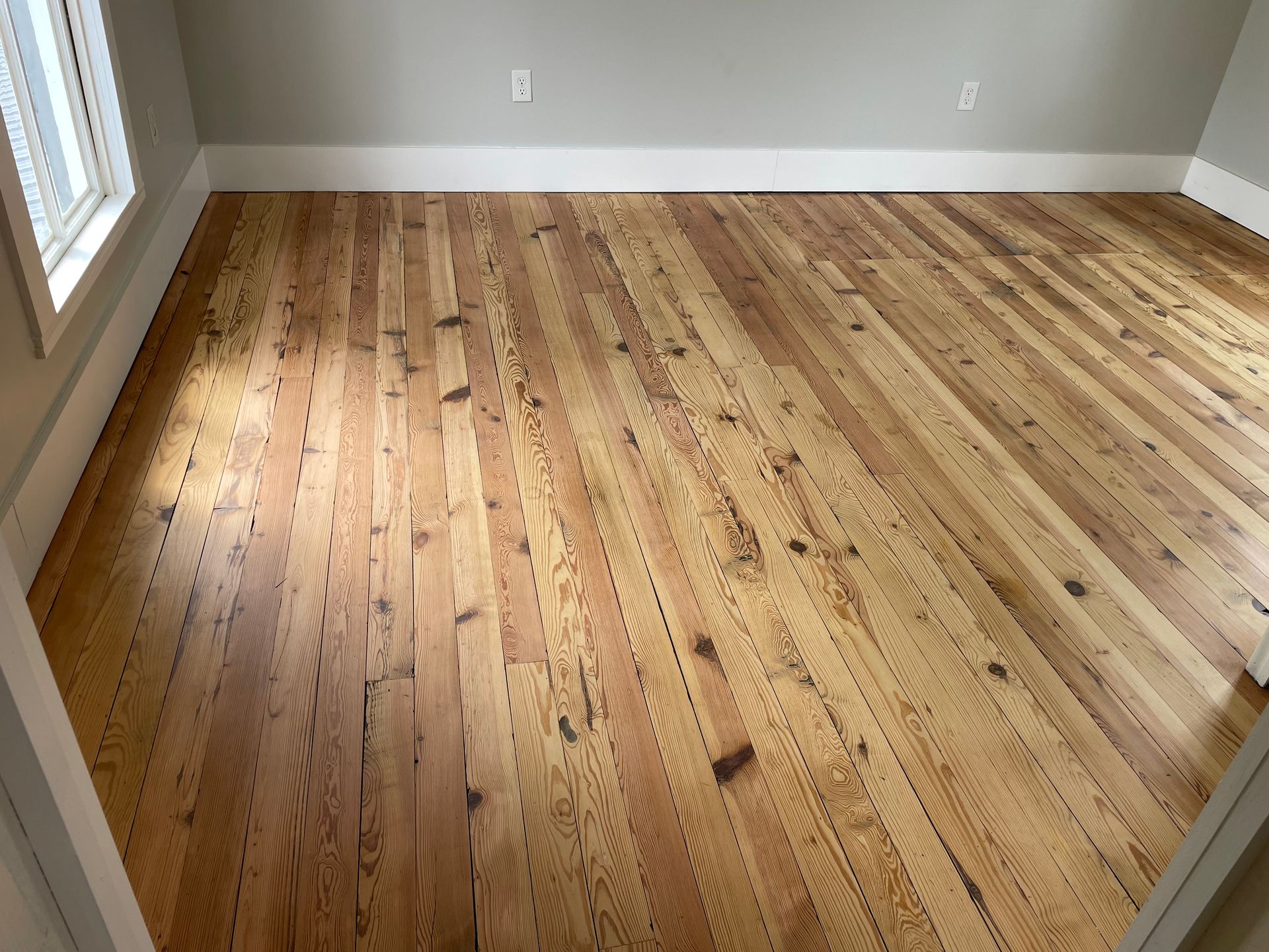 A room with a wooden floor and a window