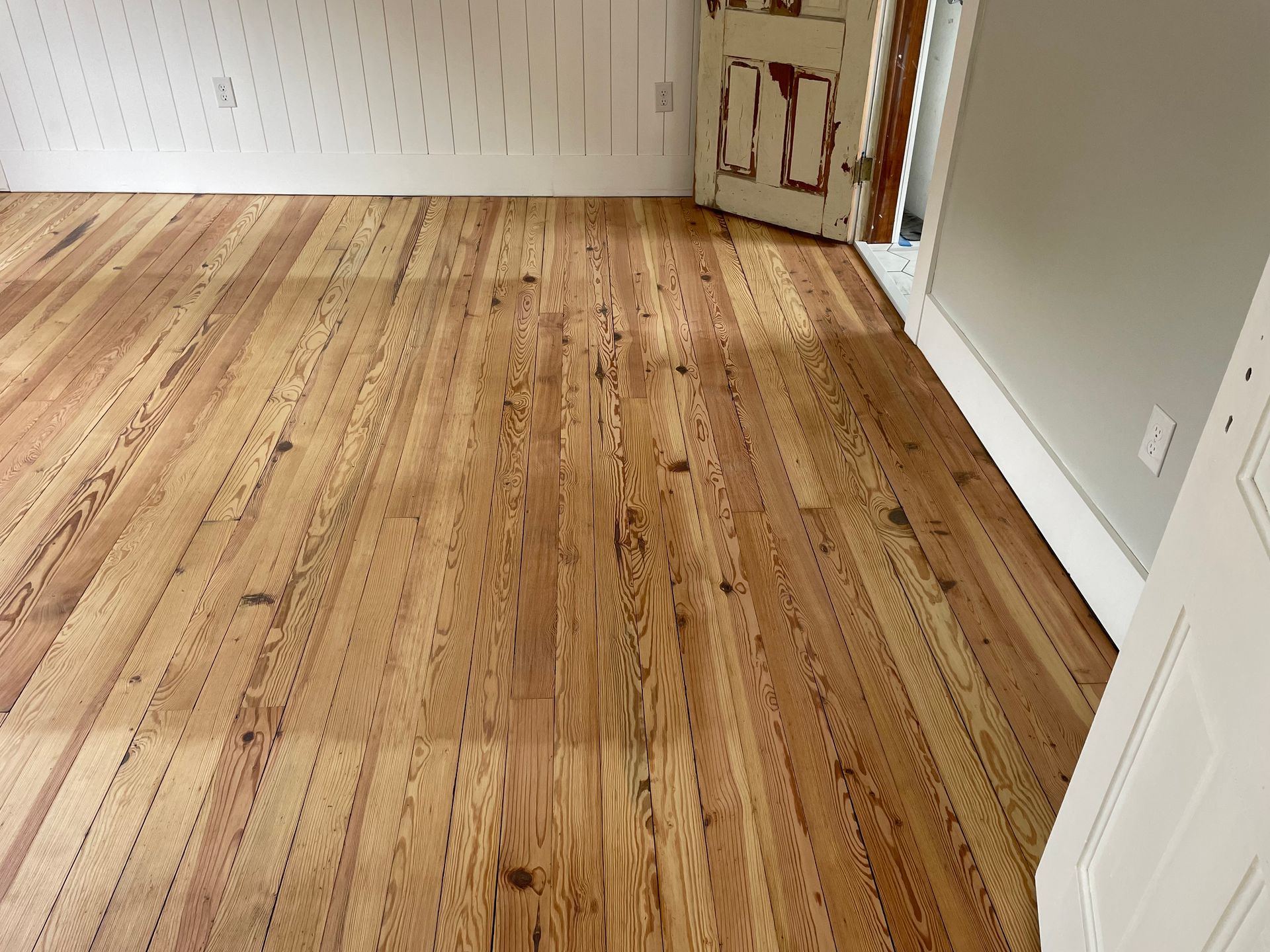 A room with a wooden floor and a door.